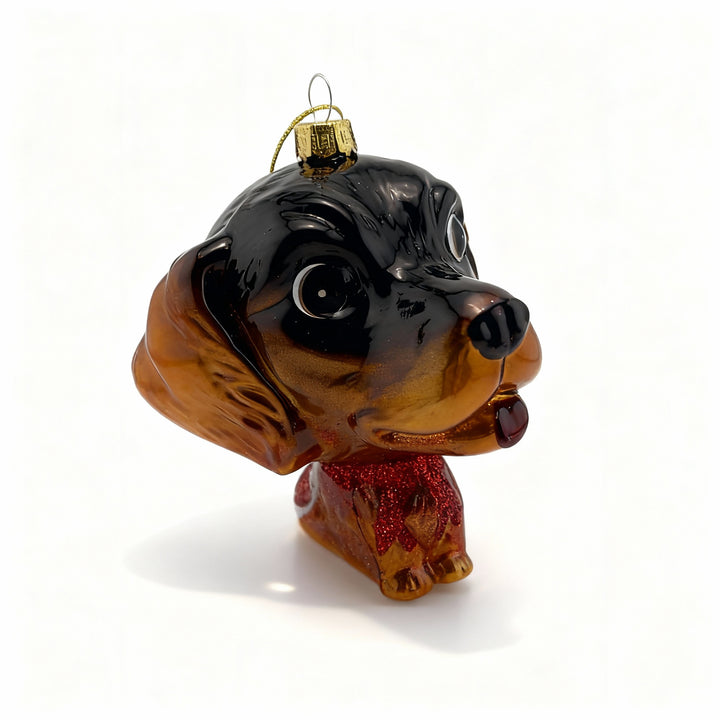 Glass dachshund Christmas ornament on white background with enhanced details, shiny and colorful holiday decoration