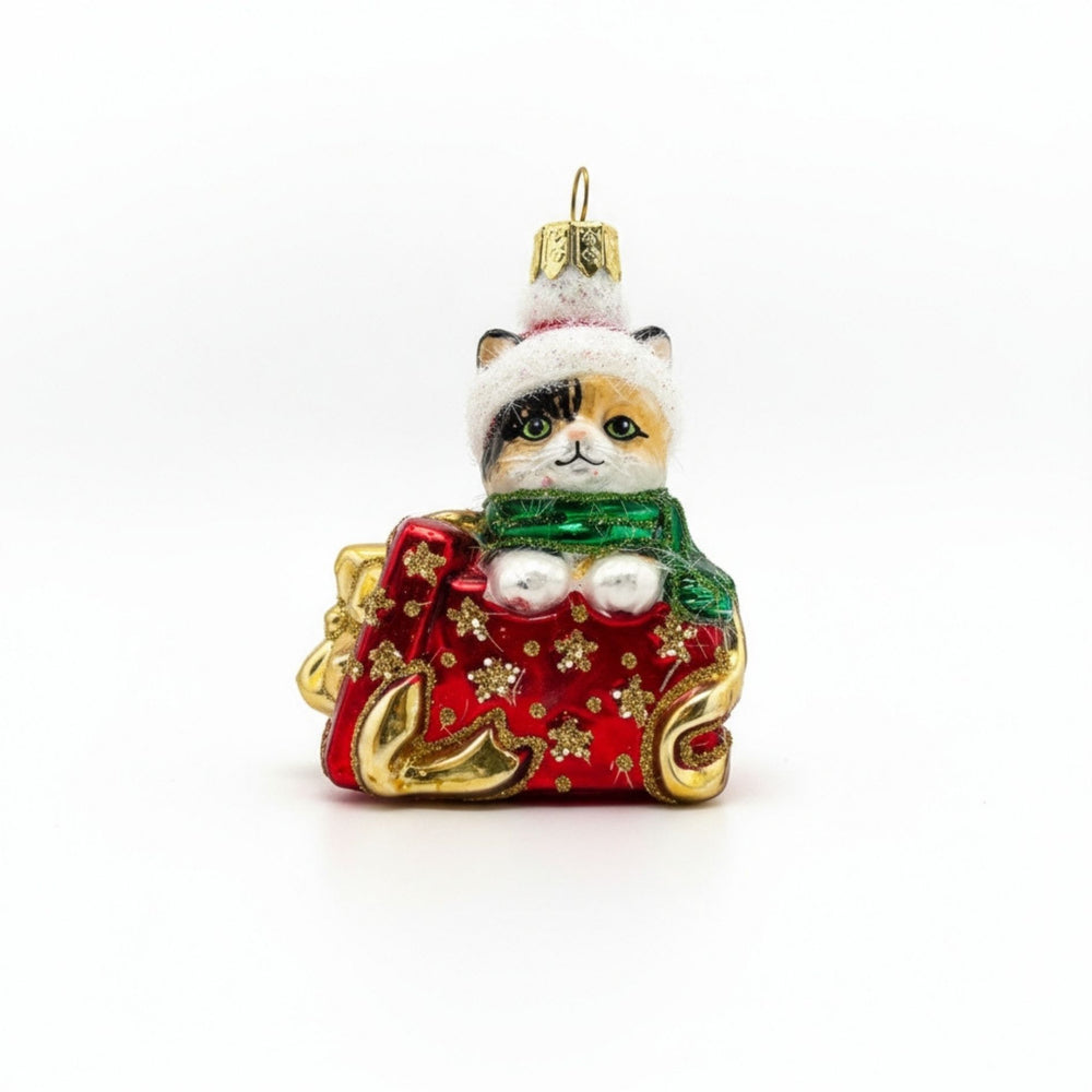 Handcrafted glass ornament of a red kitten popping out of a Christmas gift box