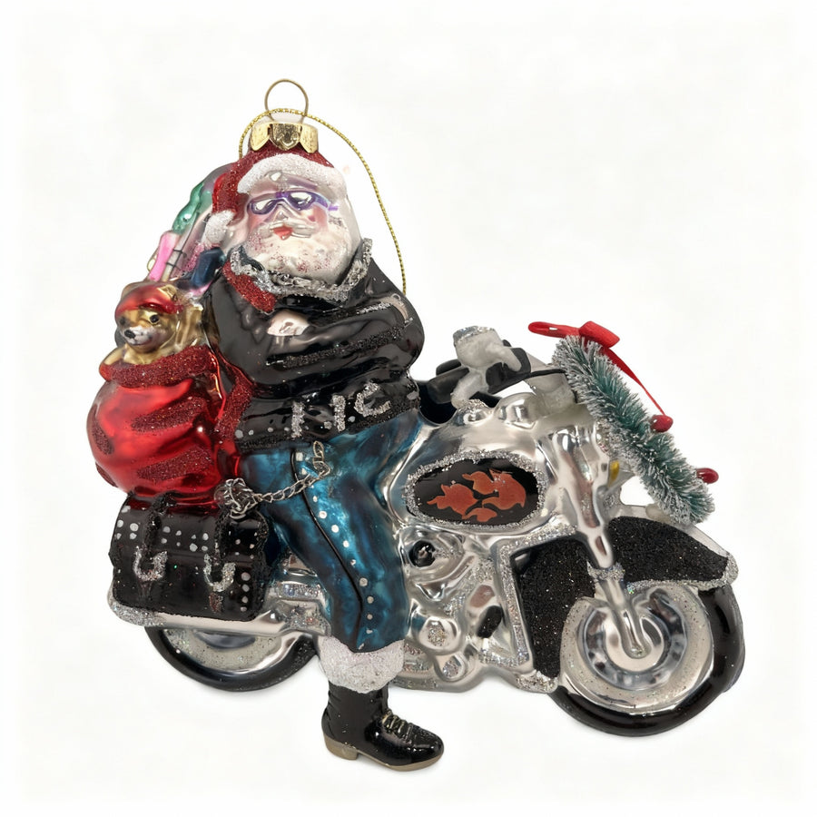 Handcrafted glass Christmas ornament of Santa Claus riding a motorcycle.