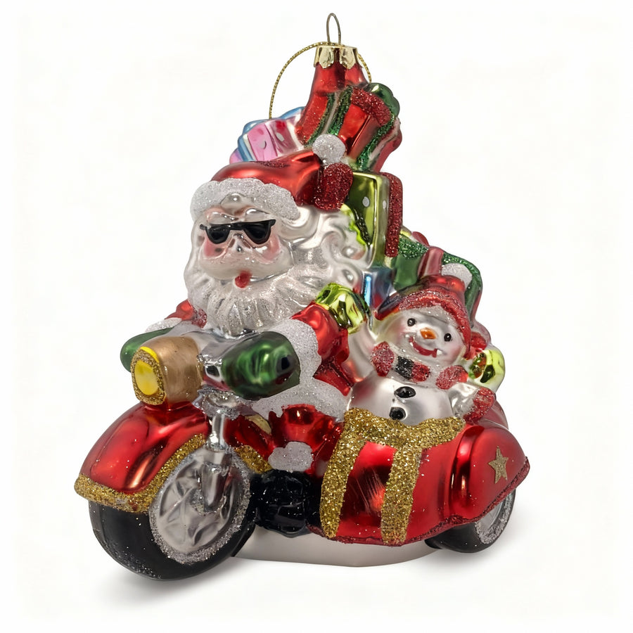 Glass Christmas ornament of Santa Claus driving a sidecar with a snowman passenger.