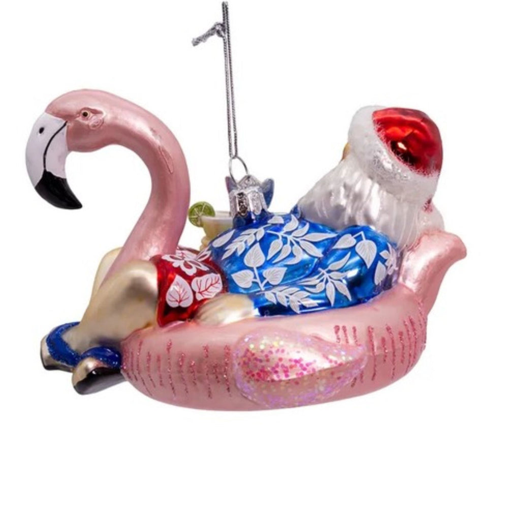 Back view of handcrafted glass Christmas ornament featuring Santa in a swimsuit sitting in a pink flamingo float.